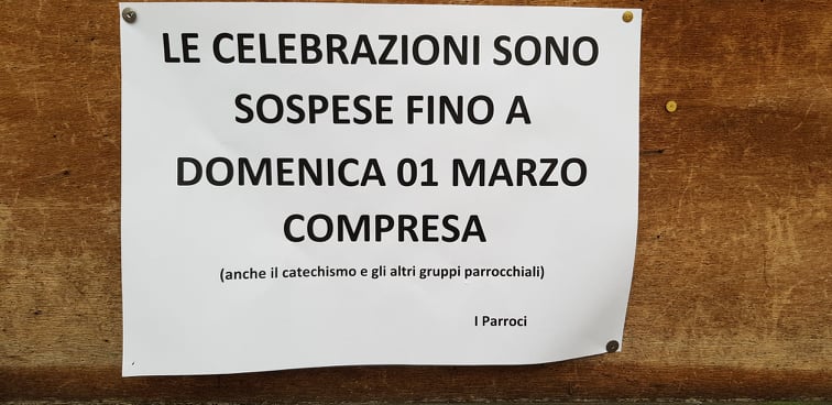 An der Tür einer Kirche in Norditalien informiert ein Aushang die Gemeindemitglieder über die Absage aller Gottesdienste und lädt sie ein, die Aschermittwochsmesse und die Sonntagsmesse im Lokalradio zu verfolgen
