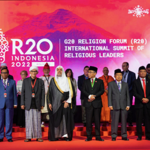 Un gruppo eterogeneo di leader religiosi in piedi davanti a uno sfondo colorato con la scritta "R20 Indonesia 2022 | G20 Religion Forum (R20) International Summit of Religious Leaders".