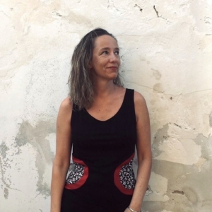La giornalista freelance italiana Federica Tourn in piedi contro un muro esterno bianco e consumato dalle intemperie