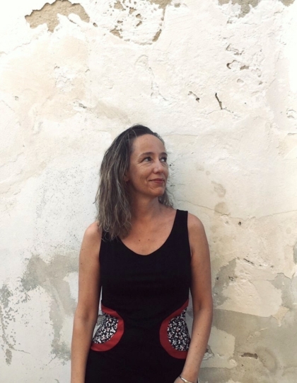 La giornalista freelance italiana Federica Tourn in piedi contro un muro esterno bianco e consumato dalle intemperie