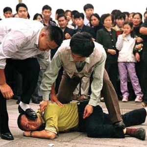 Un praticante del Falun Gong bloccato dalla polizia in piazza Tiananmen