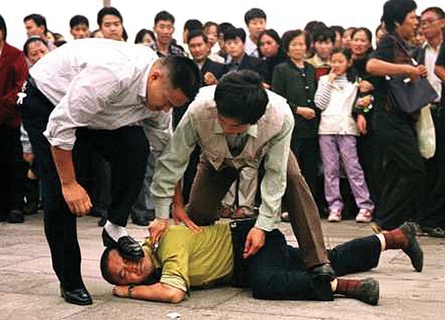 Praticante de Falun Gong imobilizado pela polícia na Praça de Tiananmen