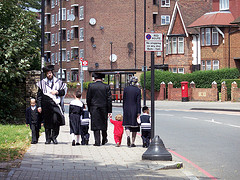 Familias judías jasídicas caminando juntas por la acera de una ciudad