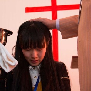 Una giovane donna viene battezzata a Shunyi