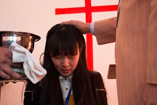 Uma jovem a ser baptizada em Shunyi