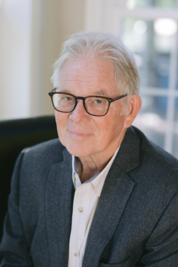 Stephen Hill, sitting, looking into the camera